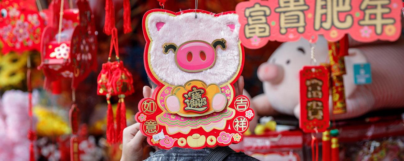 Un hombre pasea entre adornos con forma de cerdo en un puesto callejero con motivo de la próxima celebración del Año Nuevo Chino. Foto: Wallace Woon / EFE